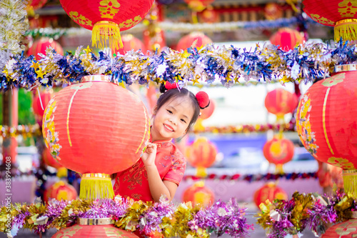 cute little asian girl in chinese traditional dress smiling in the temple.Happy chinese new year concept.