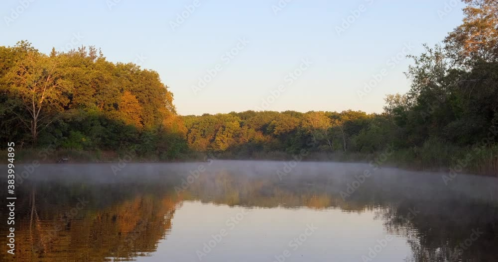 Foggy river. Calm morning on the river in the fog, trees reflected in the water. Silence and natural beauty. Nature in autumn Foggy river. Calm morning on the river in the fog, trees reflected in the water. Silence and natural beauty. Nature in autumn