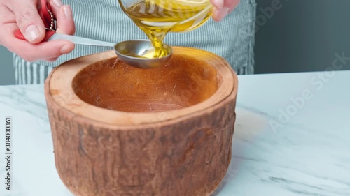 Measuring a tablespoon of Olive Oil with a set of Measuring Spoons in 4K.  Concept of a close-up of adding oil into the food in a preparation dish.