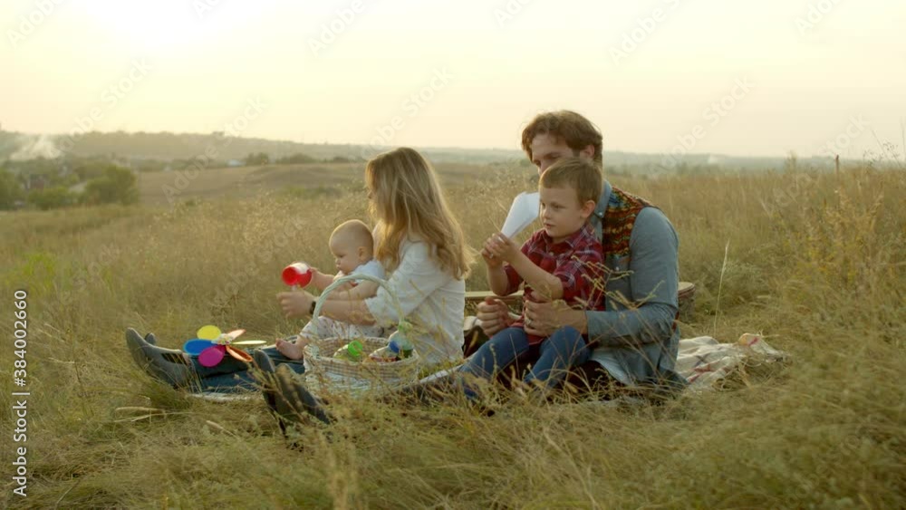 Parents playing with kids during picnic in field Parents playing with kids during picnic in field