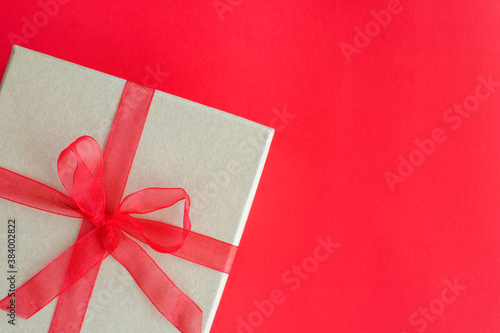 Christmas gift box on red background in the corner with empty space for text