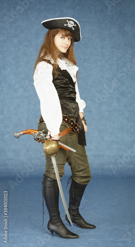 Young woman in clothes of pirate on blue background