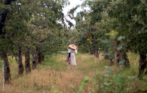 Woman in a wide hat in the garden.