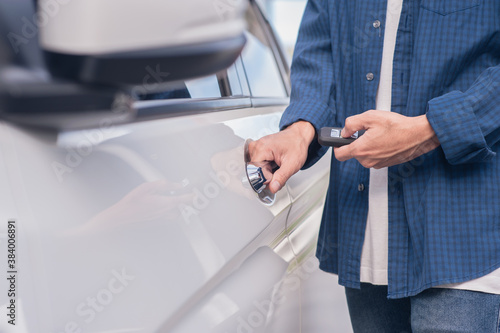 Man holding key car opening car door