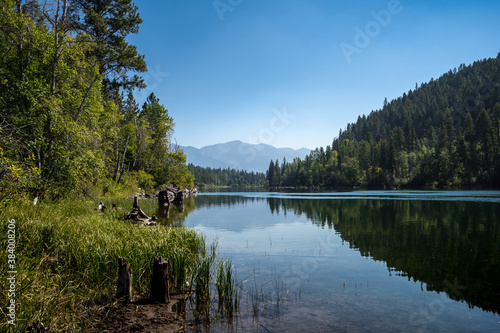 Reflection of Forested Mountains Across a Calm Lake in Montana photo