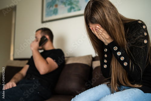 Canvas-taulu Side view on sad woman crying with hands over her face while unknown man sitting