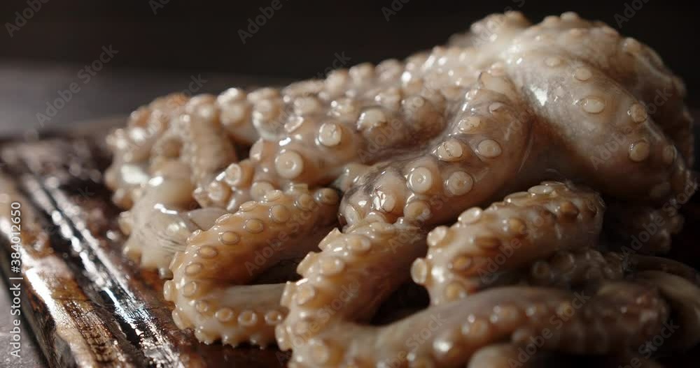 Raw octopus on the cutting board rotates. Raw octopus on the cutting board rotates.