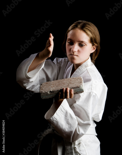 Young girl karate chopping a brick photo