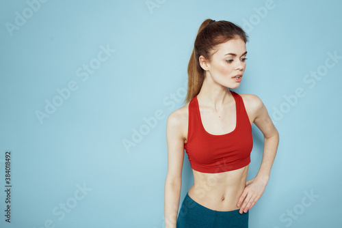 Fototapeta Naklejka Na Ścianę i Meble -  Sportive woman red tank top workout lifestyle gym blue background