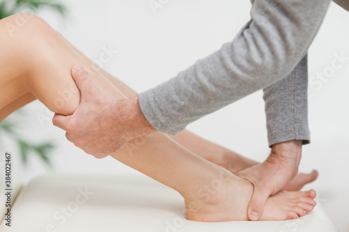 Bild auf Leinwand Doctor holding the calf of a patient