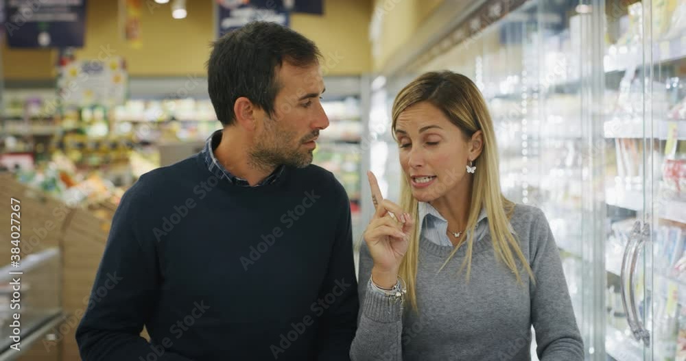 Authentic shot of happy smiling married couple is having fun while shopping for groceries together in supermarket. Authentic shot of happy smiling married couple is having fun while shopping for groceries together in supermarket.