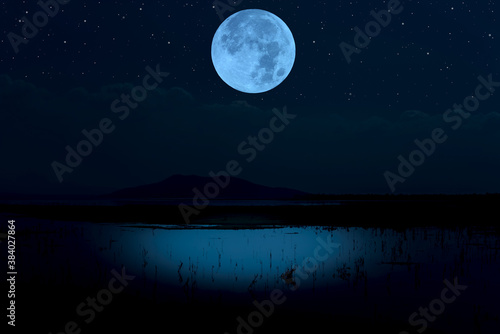 Full moon over lake at night.