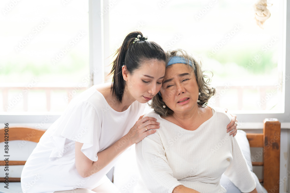 Young Asian daughter takes care of the senior mother who is sick in living room at home Young Asian daughter takes care of the senior mother who is sick in living room at home
