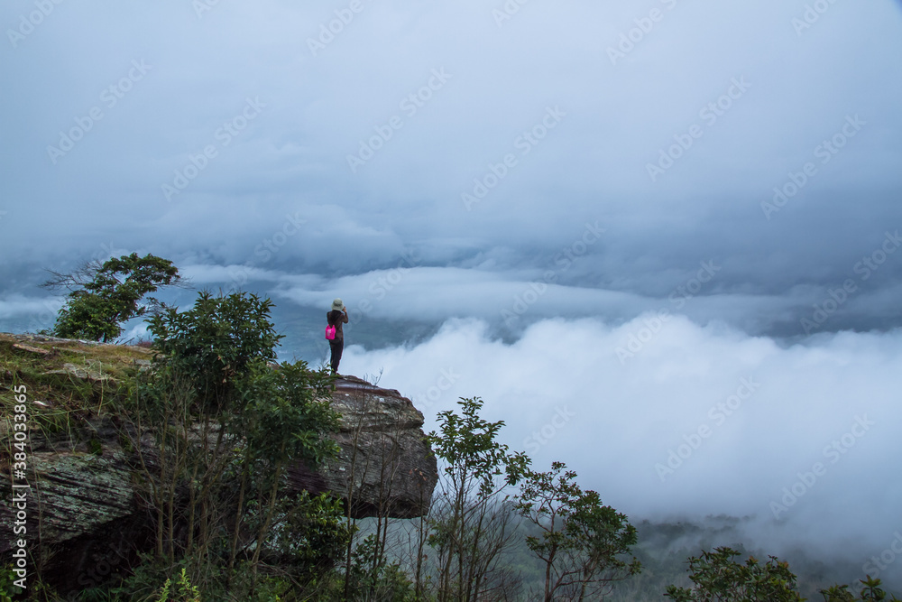 hiker on top mountain with clouds