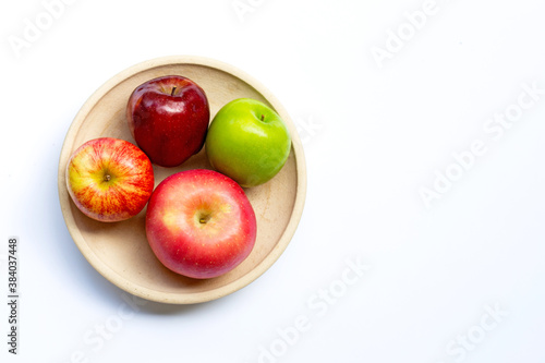 Ripe apples on plate on white background.
