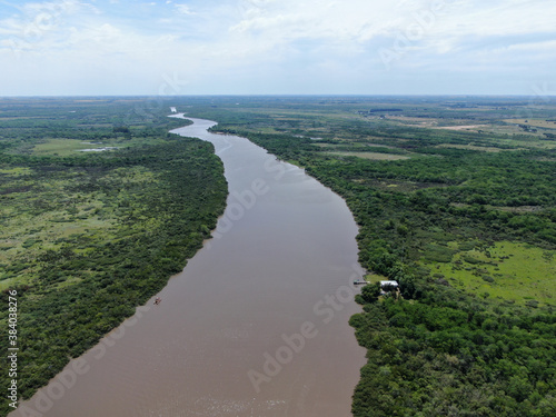 Vista aérea  arriba de un río con pequeñas curvas y muchos árboles en la costa, desde un dron.  photo