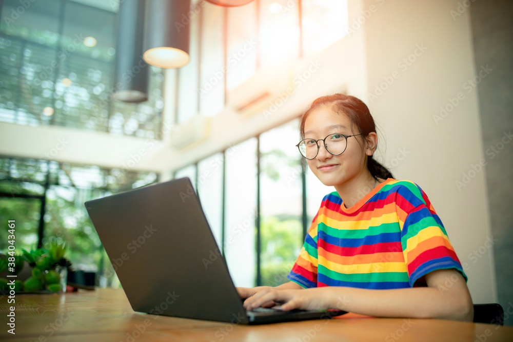 asian teenager working on computer laptop with smiling face asian teenager working on computer laptop with smiling face