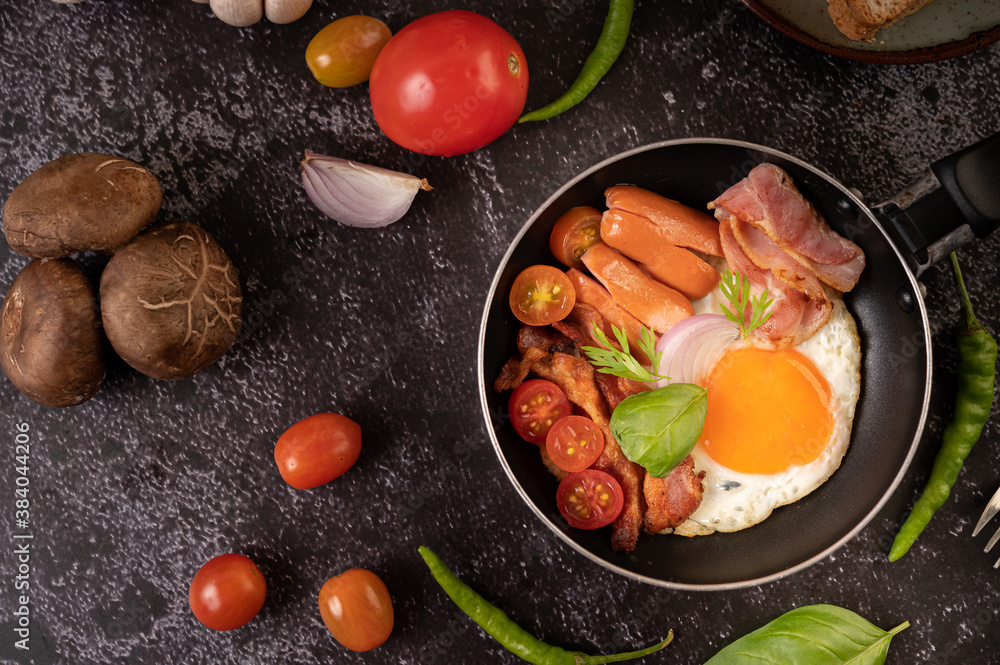Breakfast with fried eggs, sausage, and ham in a pan with tomatoes. Chili and basil. Breakfast with fried eggs, sausage, and ham in a pan with tomatoes. Chili and basil.
