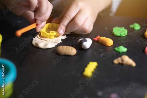Child playing with colorful clay making food bakery