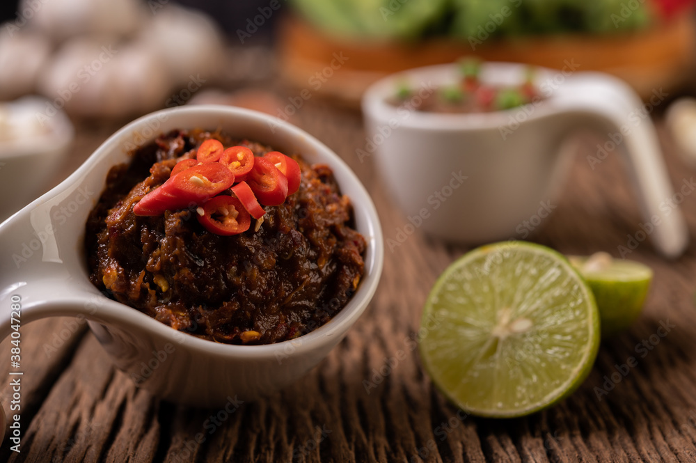 Red Eye Chili Paste with Lemon and Chili on Wooden Floor Red Eye Chili Paste with Lemon and Chili on Wooden Floor