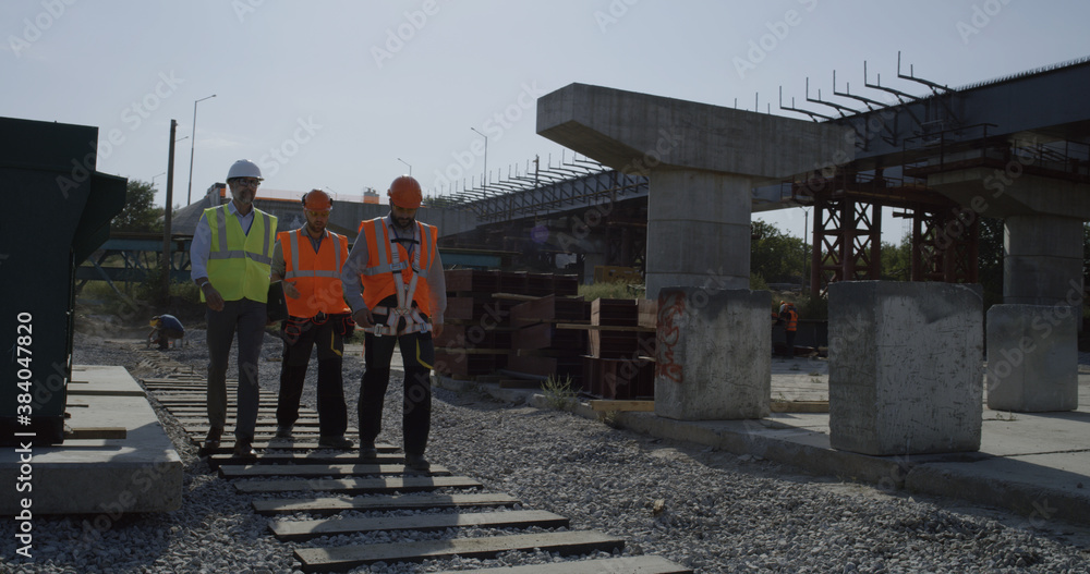 Team of engineers walking on construction site