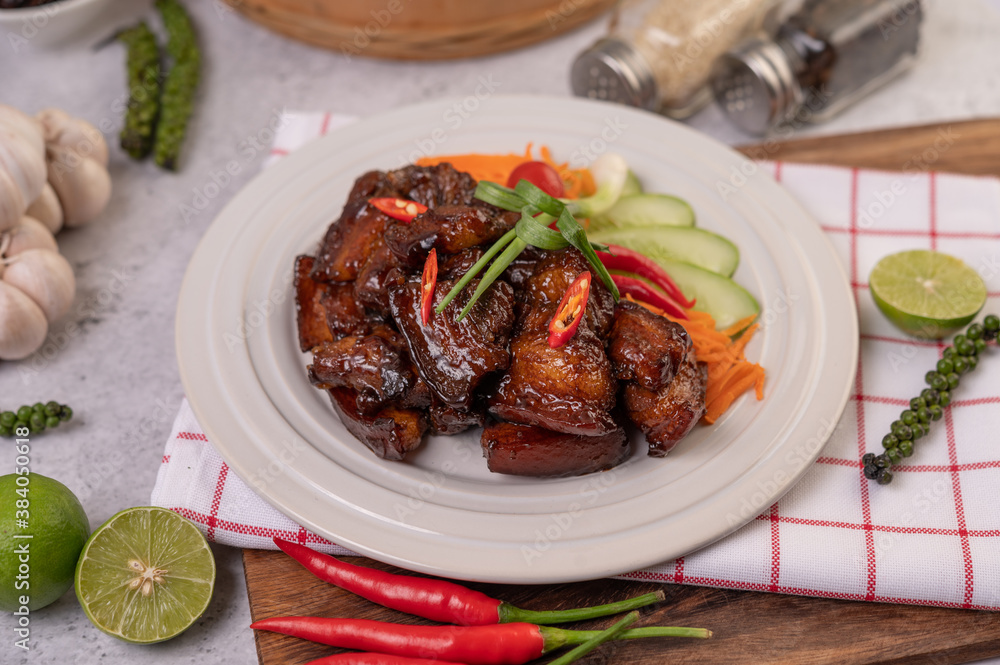 Sweet pork on a white plate with chopped scallions, chili, lime, cucumber, tomato, and garlic. Sweet pork on a white plate with chopped scallions, chili, lime, cucumber, tomato, and garlic.