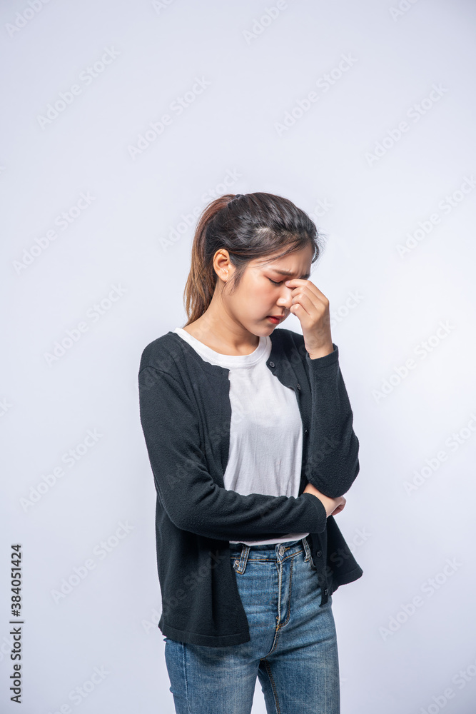 A sick woman with a headache and put her hand on her head A sick woman with a headache and put her hand on her head