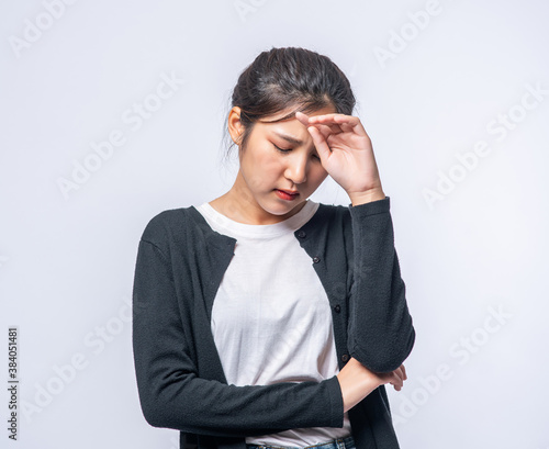 A sick woman with a headache and put her hand on her head