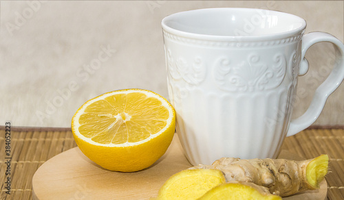 A Cup of ginger tea with honey and lemon on a wooden round natural tray, treated at home