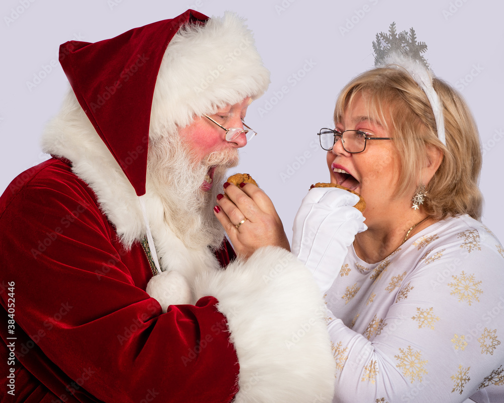 Happy Santa Claus with Mrs. Claus posing with Christmas cookies Happy Santa Claus with Mrs. Claus posing with Christmas cookies