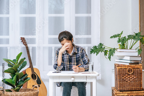 A woman sitting at a desk analyzes the document and is stressed. photo