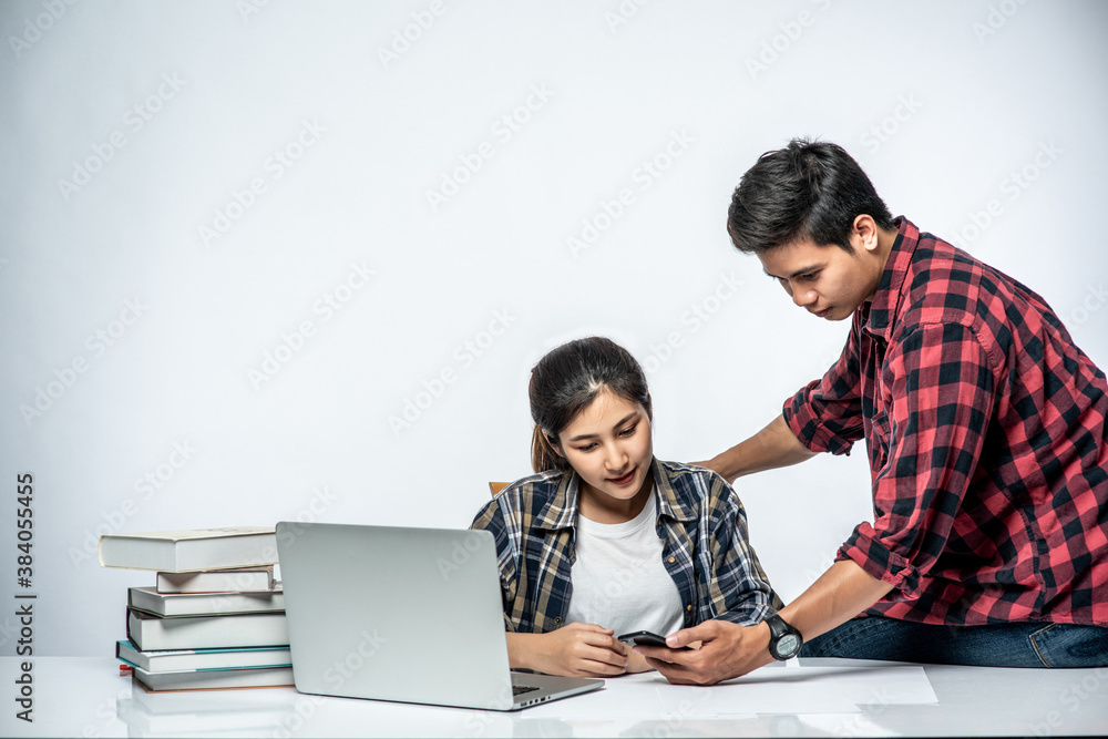 Men teach women how to work with laptops at work. Men teach women how to work with laptops at work.