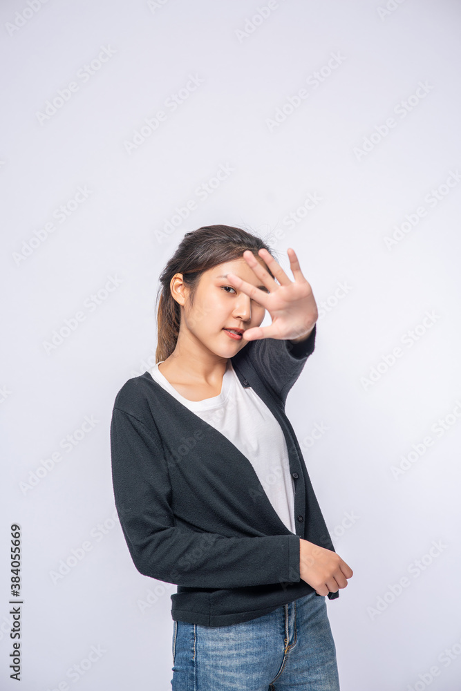 Girl in white stretch jeans and do hand prohibition sign on white background. Girl in white stretch jeans and do hand prohibition sign on white background.