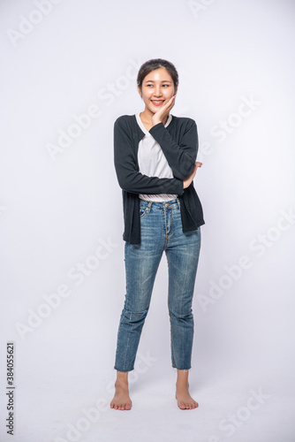 A smiling woman happily in a black shirt, standing jeans, smiling happily.