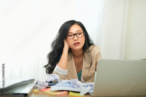 Sad Woman Looking At Laptop Touching Head Having Problems At Work Sitting In Modern Office