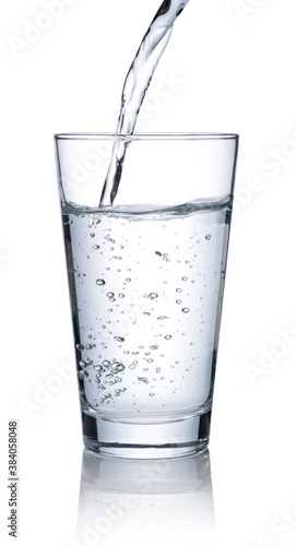 Pour water into a glass placed on a white background.