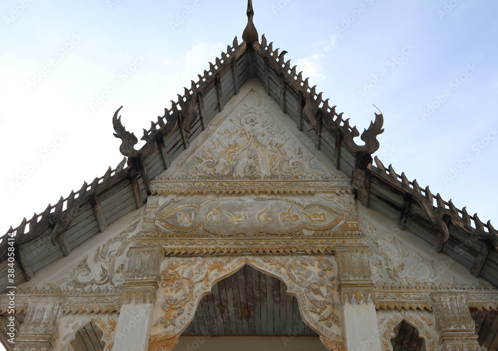 Old Thai temple gable designed - by beautiful old builders and lettered - indicating the year - built in the countryside of Thailand.