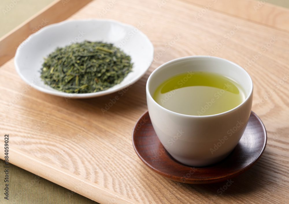 Green tea and tea leaves on a wooden tray Green tea and tea leaves on a wooden tray