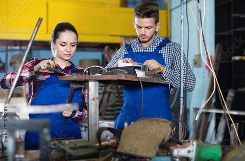 Portrait of glad man with young smiling woman who are working together in workshop.