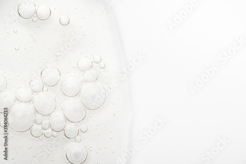 Obraz na płótnie Sample of the texture of liquid hyaluronic gel for face care on white background. Cosmetic moisturizing beauty product for gentle cleansing of female skin with acids. Smeared transparent bubble serum w salonie