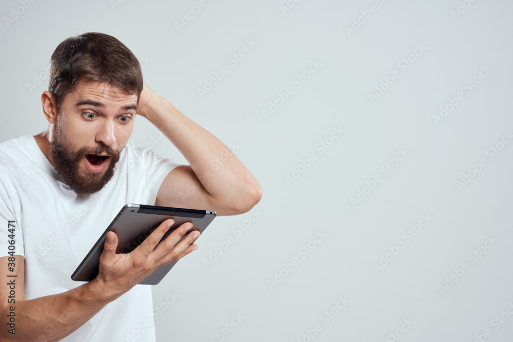 emotional man with tablet in hand touch screen new technologies light background cropped view Copy Space emotional man with tablet in hand touch screen new technologies light background cropped view Copy Space