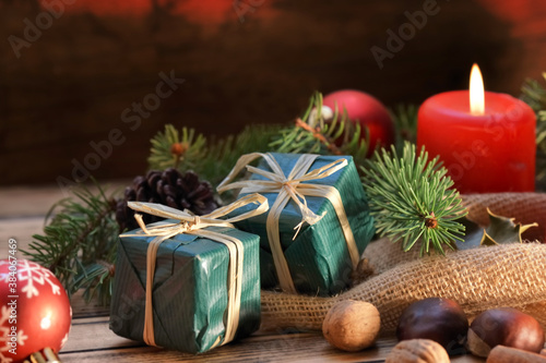 traditional christmas decoration on wooden background with candles and gifts