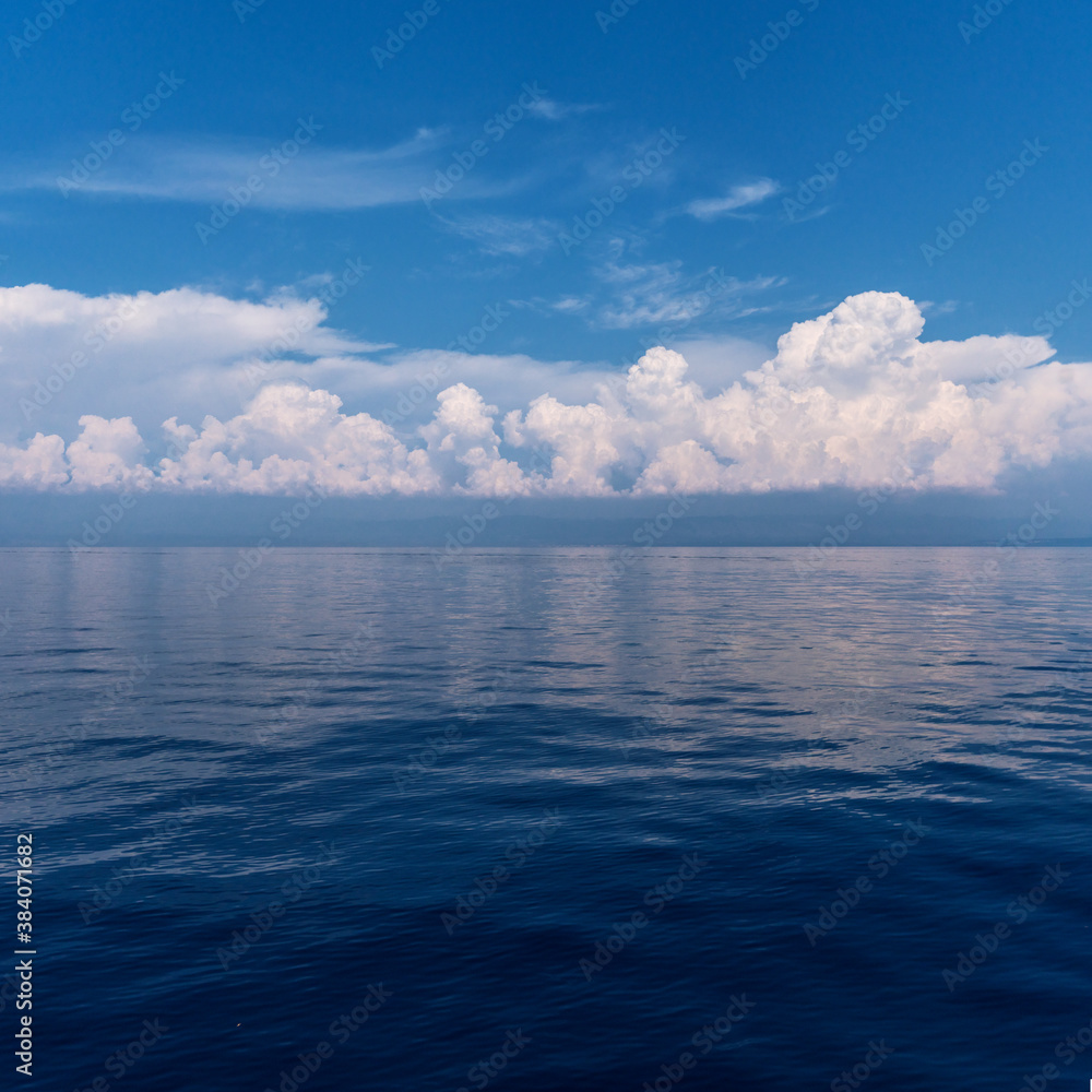 Calm sea and cloudy sky pierced with sun rays. Beautiful nature background. Calm sea and cloudy sky pierced with sun rays. Beautiful nature background.