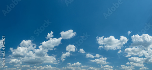 Some light cumuliform clouds in the clean blue sky. © volff