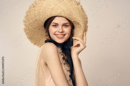 romantic girl in beige dress and in straw hat with black ribbon emotions portrait of model cropped view