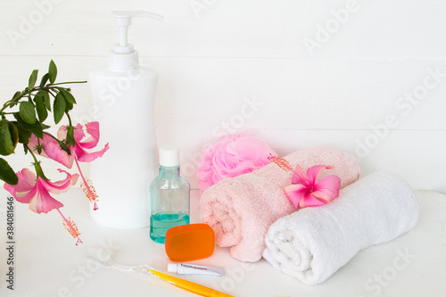 herbal liquid soap health care for body skin and mouthwash ,toothbrush ,toothpaste health care for oral cavity with terry cloth ,pink flower hibiscus arrangement flat lay style on background white 