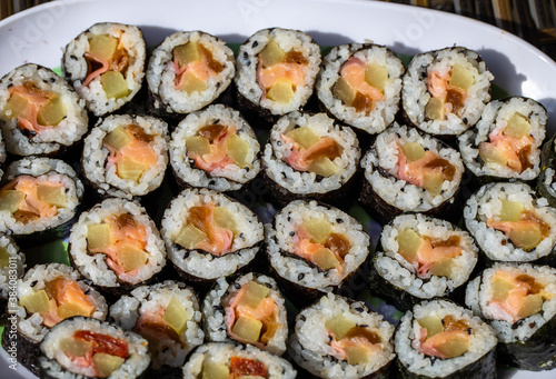 Top view of stack of Japanese sushi maki roll plate. Served in Japanese bar restaurant with chopstick