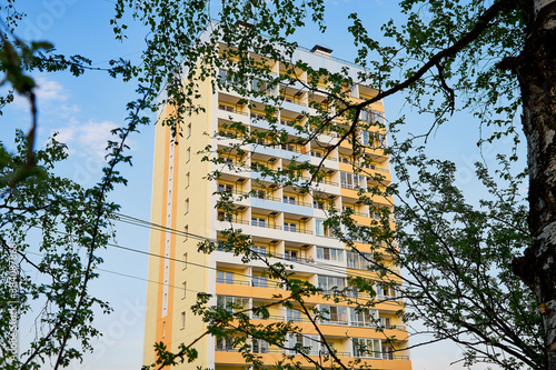 Big house and blue sky with clouds behind. Big block of flats in a summer day photo