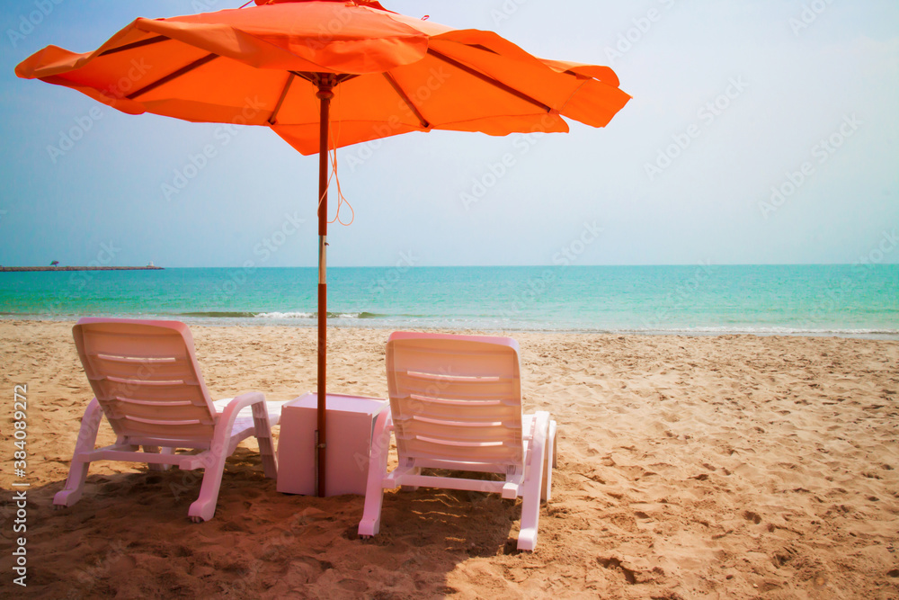 Orange umbrellas on white sandy beach along the beautiful sea in Cha Am, Thailand.
