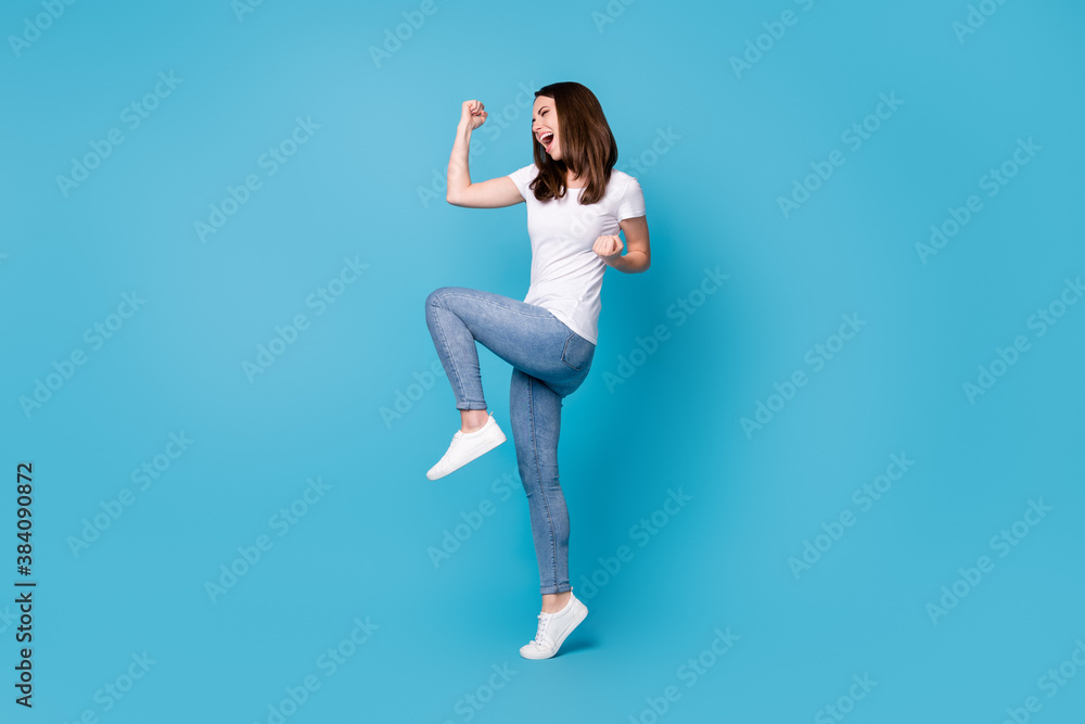Full length profile photo of attractive crazy lady good mood raise fists screaming rejoicing overjoyed football sports fan supporter wear casual white t-shirt isolated blue color background Full length profile photo of attractive crazy lady good mood raise fists screaming rejoicing overjoyed football sports fan supporter wear casual white t-shirt isolated blue color background